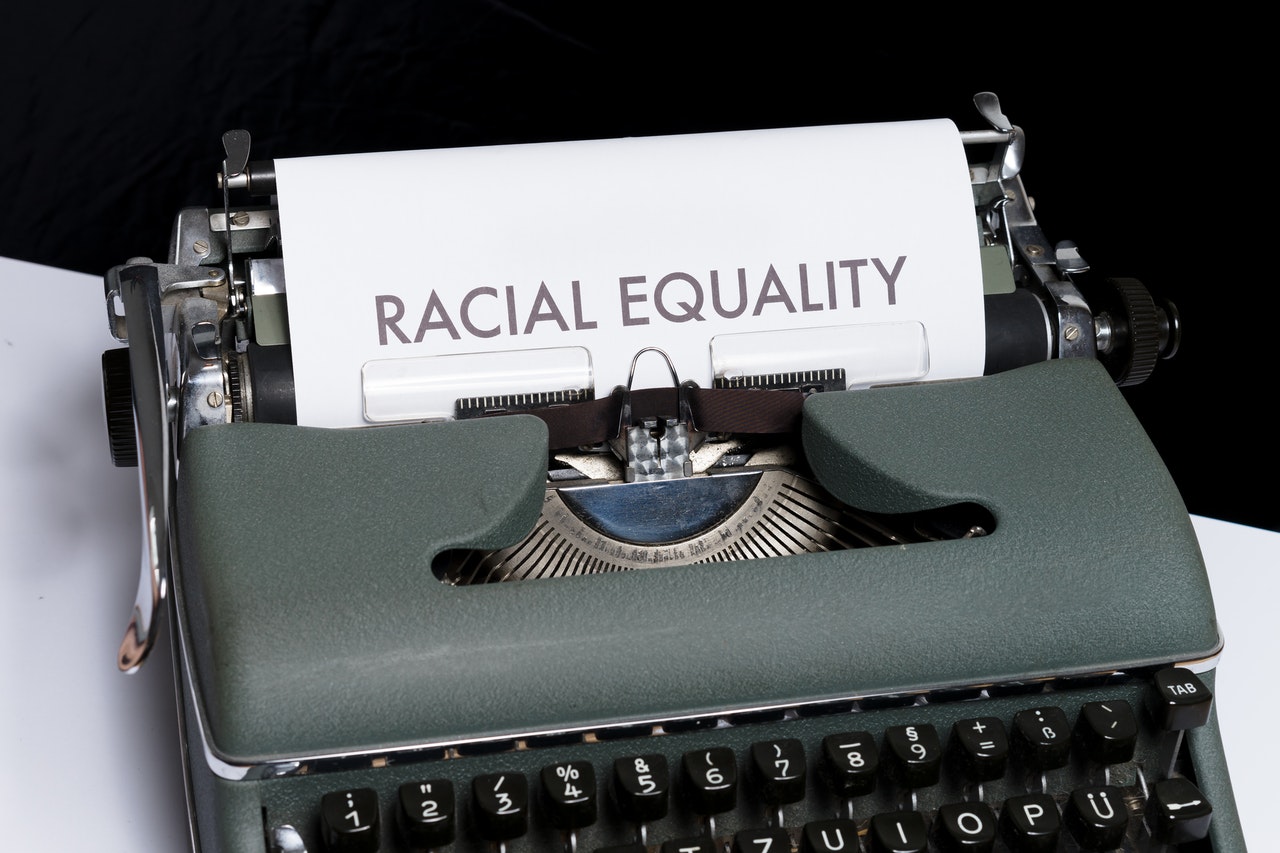 Photo of a typewriter with a sheet of paper coming out that says "racial equality."