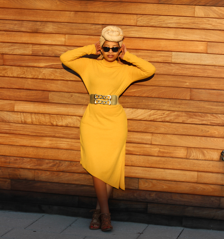 Keri Gray in a mustard dress, sunglasses, and a tan headwrap.
